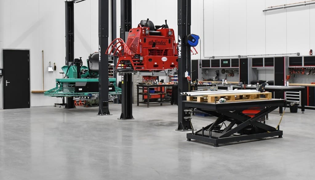 Betonwereld onderhoudsworkshop met machines op hefbruggen